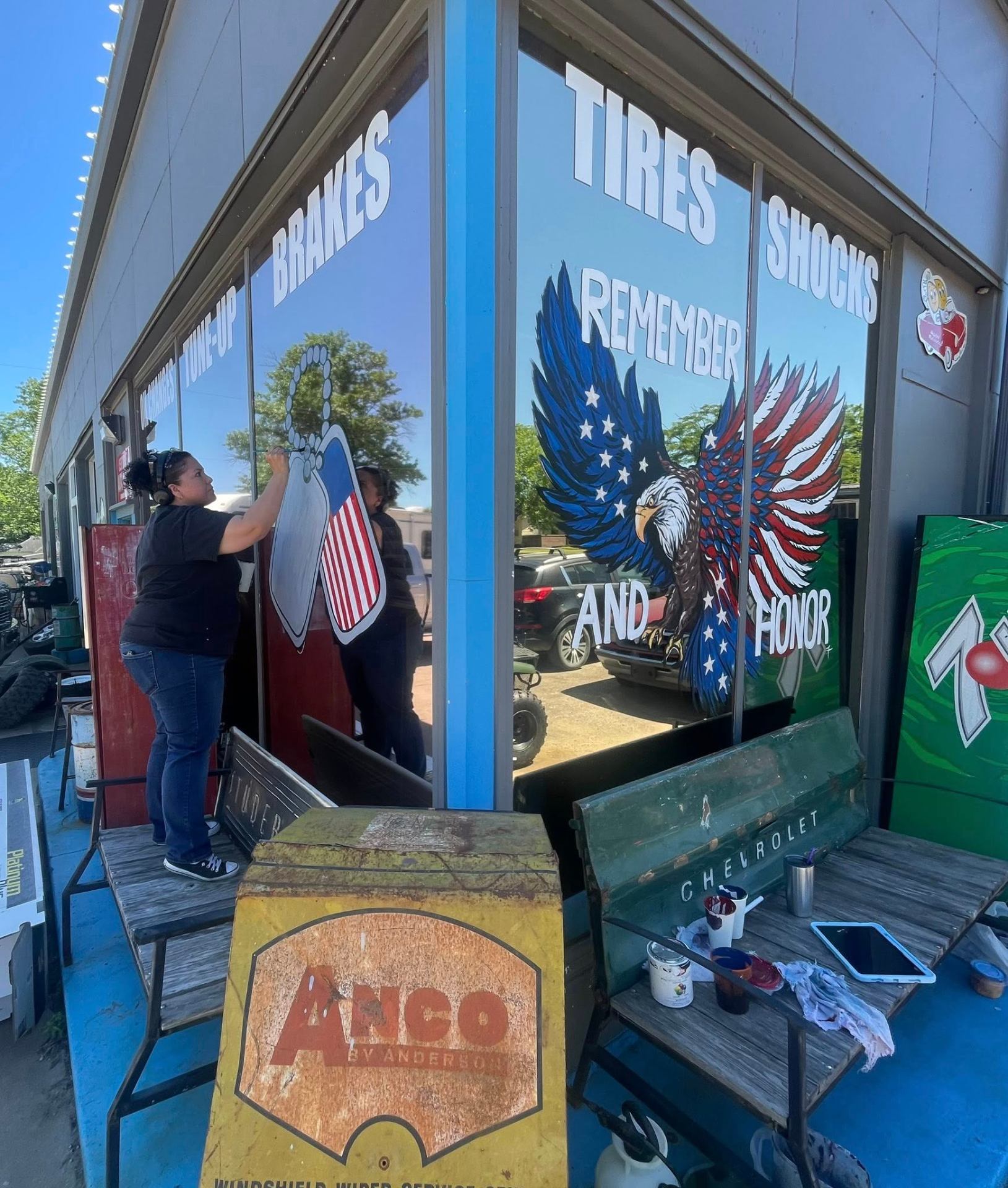 Hand-painted patriotic eagle 'Remember and Honor' mural on the shop windows